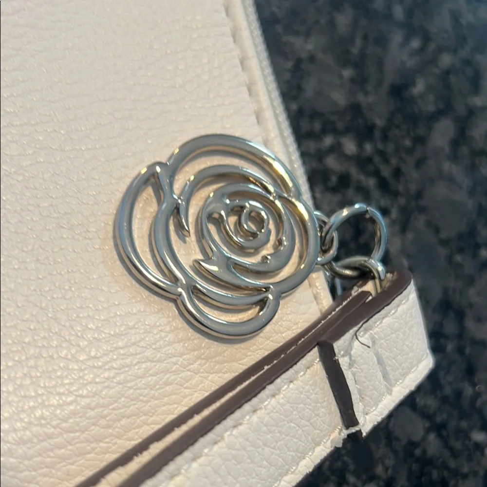 Carlos Santana White Textured Wristlet with Zipper Closure and rose medal accent